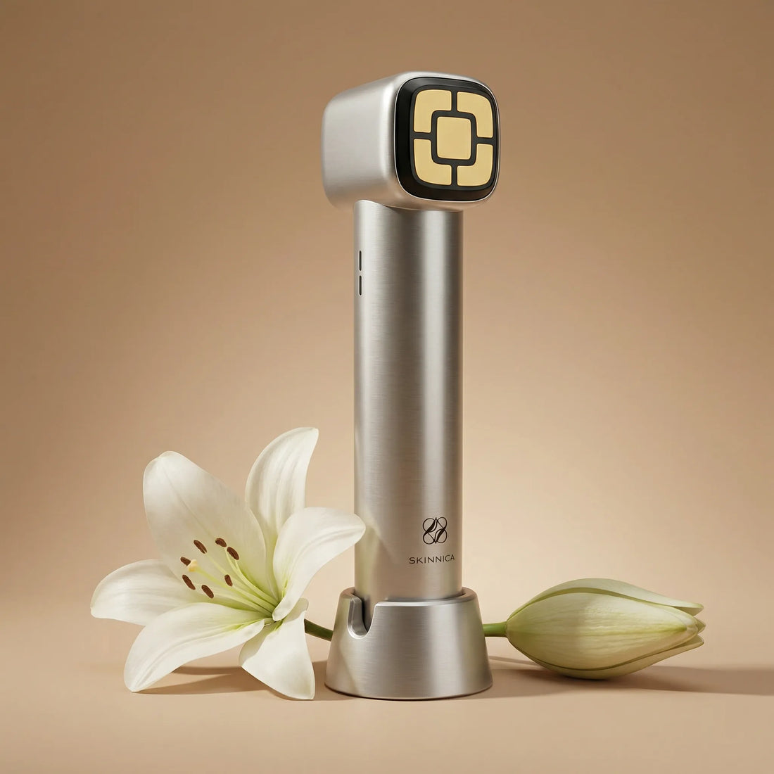SKINNICA OMNI beauty device set against a neutral background with delacate flowers placed nearby