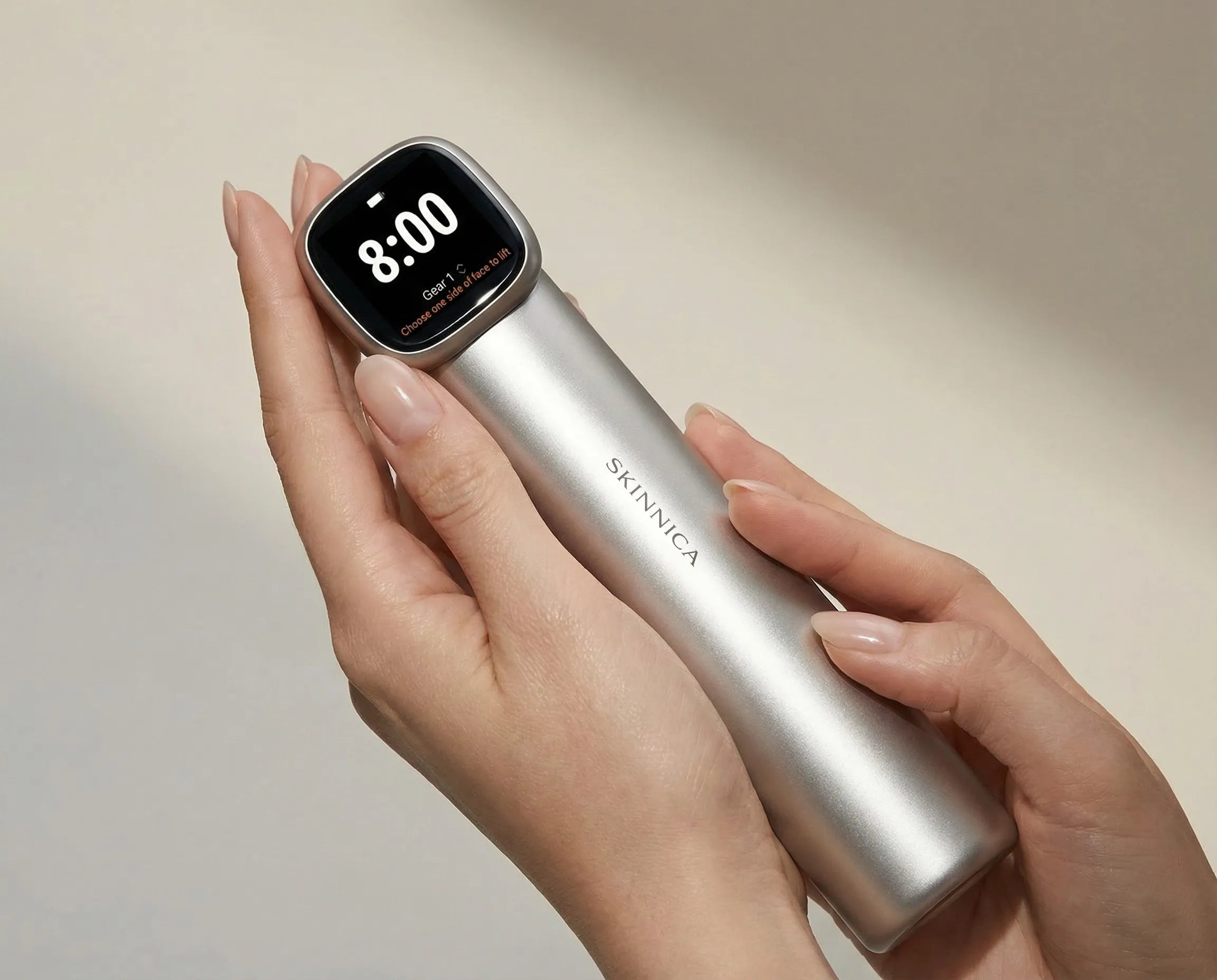 closeup view of the SKINNICA OMNI at home beauty device held in a model's hands